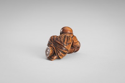 Lot 349 - A WOOD NETSUKE OF A BOY ON A BAMBOO LOG