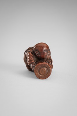 Lot 349 - A WOOD NETSUKE OF A BOY ON A BAMBOO LOG
