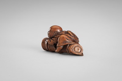 Lot 349 - A WOOD NETSUKE OF A BOY ON A BAMBOO LOG