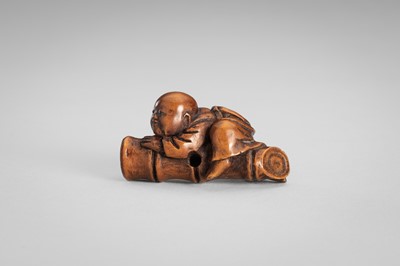 Lot 349 - A WOOD NETSUKE OF A BOY ON A BAMBOO LOG