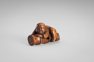 Lot 349 - A WOOD NETSUKE OF A BOY ON A BAMBOO LOG