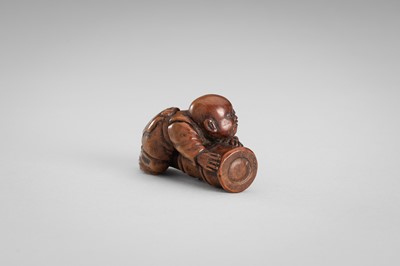 Lot 349 - A WOOD NETSUKE OF A BOY ON A BAMBOO LOG