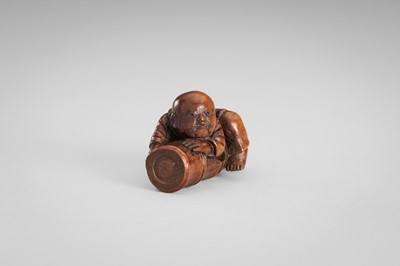 Lot 349 - A WOOD NETSUKE OF A BOY ON A BAMBOO LOG
