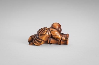 Lot 349 - A WOOD NETSUKE OF A BOY ON A BAMBOO LOG