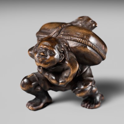 Lot 238 - MINKOKU: AN AMUSING WOOD NETSUKE OF A MAN AND KAPPA