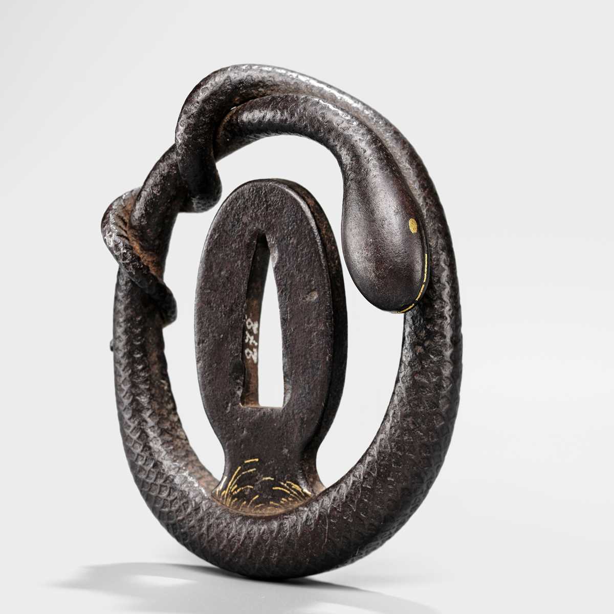Lot 52 - A RARE IRON MYOCHIN SCHOOL SUKASHI TSUBA IN THE FORM OF A SNAKE