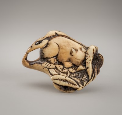 Lot 1257 - A LARGE KYOTO SCHOOL ANTLER NETSUKE OF A RESTING BOAR