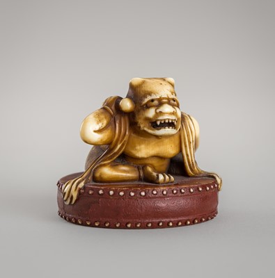 Lot 1402 - AN IVORY NETSUKE OF AN ONI WITH DRUM