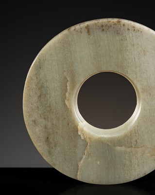 Lot 200 - A PALE CELADON JADE DISK, BI, LATE NEOLITHIC-WESTERN ZHOU PERIOD