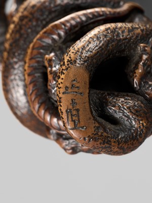 Lot 120 - MASANAO: A FINE WOOD NETSUKE OF A SNAKE PREYING ON A FROG, SANSUKUMI