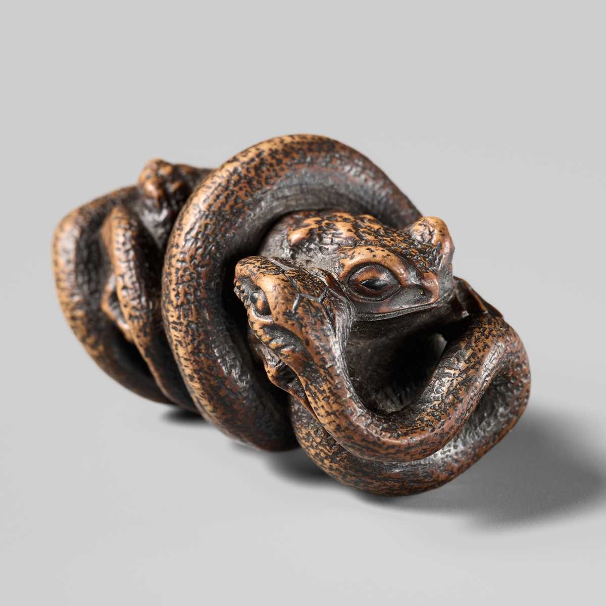 Lot 120 - MASANAO: A FINE WOOD NETSUKE OF A SNAKE PREYING ON A FROG, SANSUKUMI