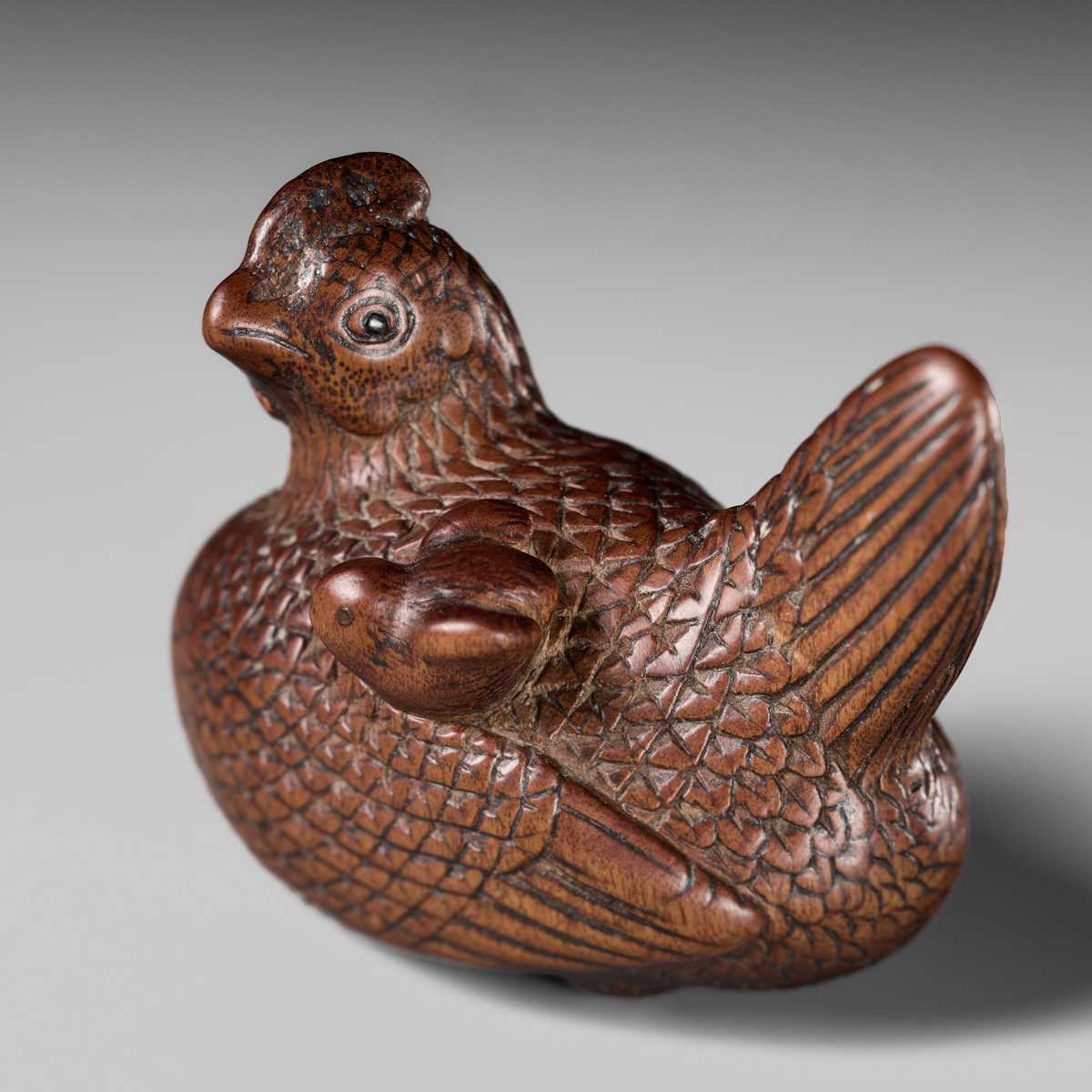 TOMOTSUNE: A SUPERB NAGOYA SCHOOL WOOD NETSUKE OF A HEN WITH TWO CHICKS