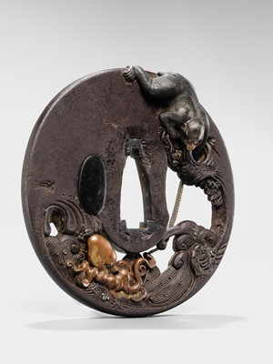 Lot 62 - AN INGENIOUS TETSUGENDO SCHOOL IRON TSUBA WITH A MONKEY CATCHING AN OCTOPUS