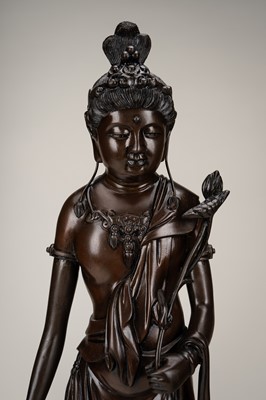 A LARGE BRONZE FIGURE OF KANNON HOLDING LOTUS BLOSSOMS