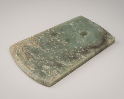 Lot 798 - A QIJIA CULTURE CELADON AND RUSSET JADE AXE