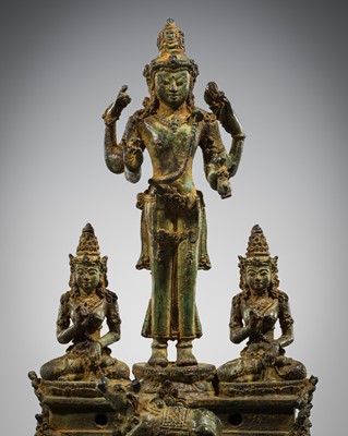 Lot 462 - A RARE BRONZE TRIAD OF SHIVA AND HIS CONSORTS PARVATI AND SATI WITH NANDI, CENTRAL JAVA, 11TH CENTURY