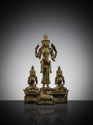 Lot 462 - A RARE BRONZE TRIAD OF SHIVA AND HIS CONSORTS PARVATI AND SATI WITH NANDI, CENTRAL JAVA, 11TH CENTURY