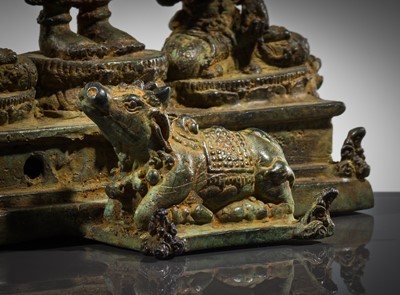 Lot 462 - A RARE BRONZE TRIAD OF SHIVA AND HIS CONSORTS PARVATI AND SATI WITH NANDI, CENTRAL JAVA, 11TH CENTURY