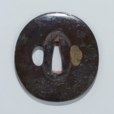 Lot 1523 - SOKO: A PATINATED BRASS TSUBA WITH A SHISHI AND PEONIES