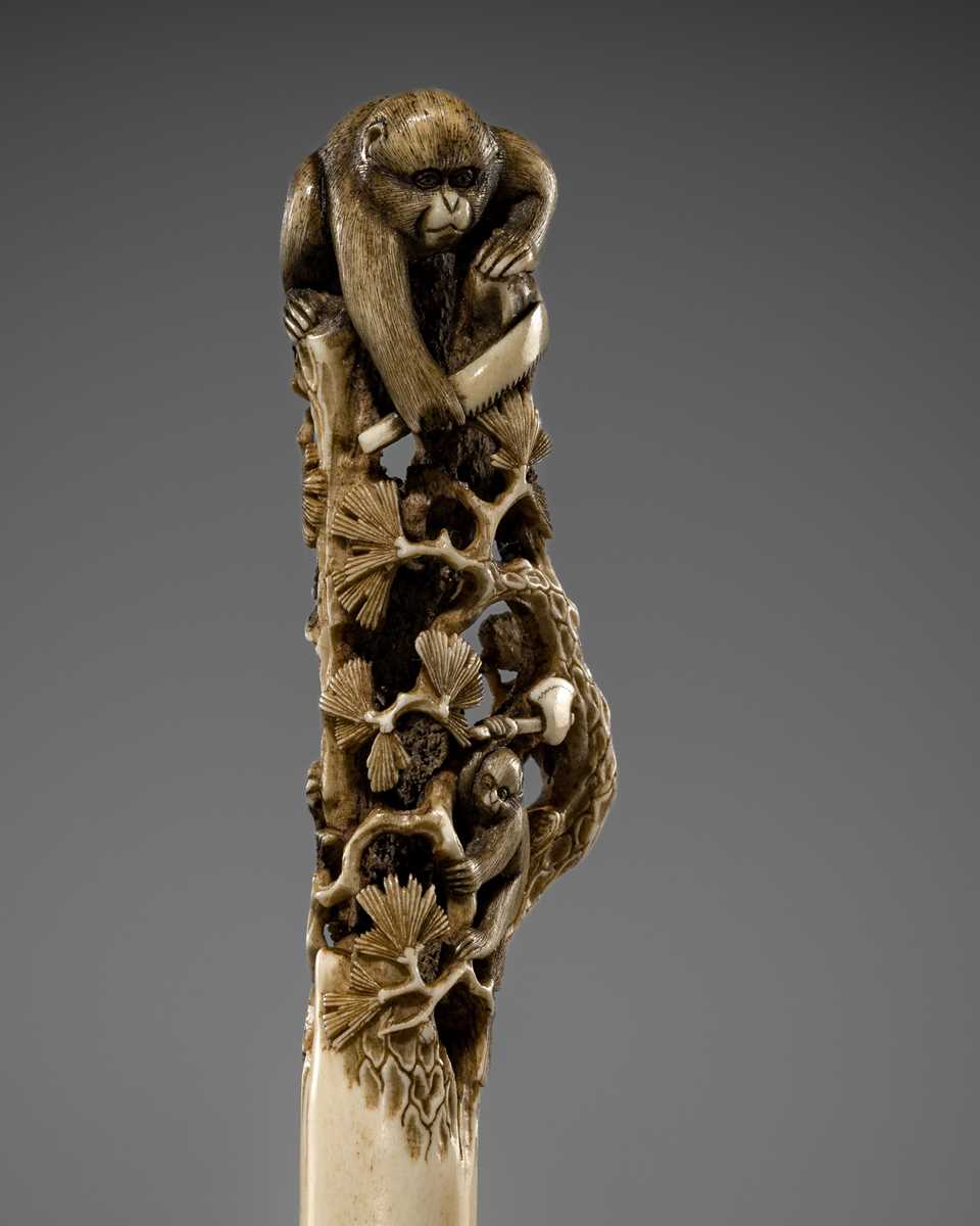 Lot 530 - AN AMUSING ANTLER CANE HANDLE OF MONKEYS AND BIRDS ON A PINE TREE