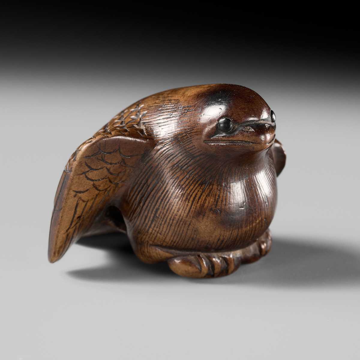 Lot 142 - YOSHINOBU: A RARE WOOD NETSUKE OF A BROODING SPARROW