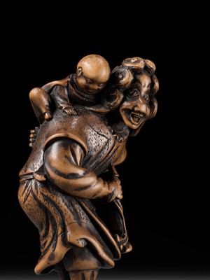 Lot 94 - A TALL WOOD NETSUKE OF A DUTCHMAN WITH CHILD