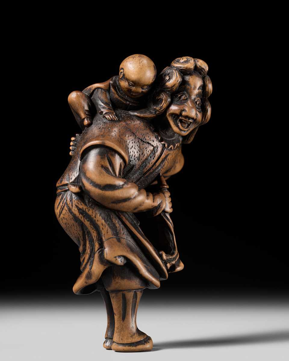 Lot 94 - A TALL WOOD NETSUKE OF A DUTCHMAN WITH CHILD