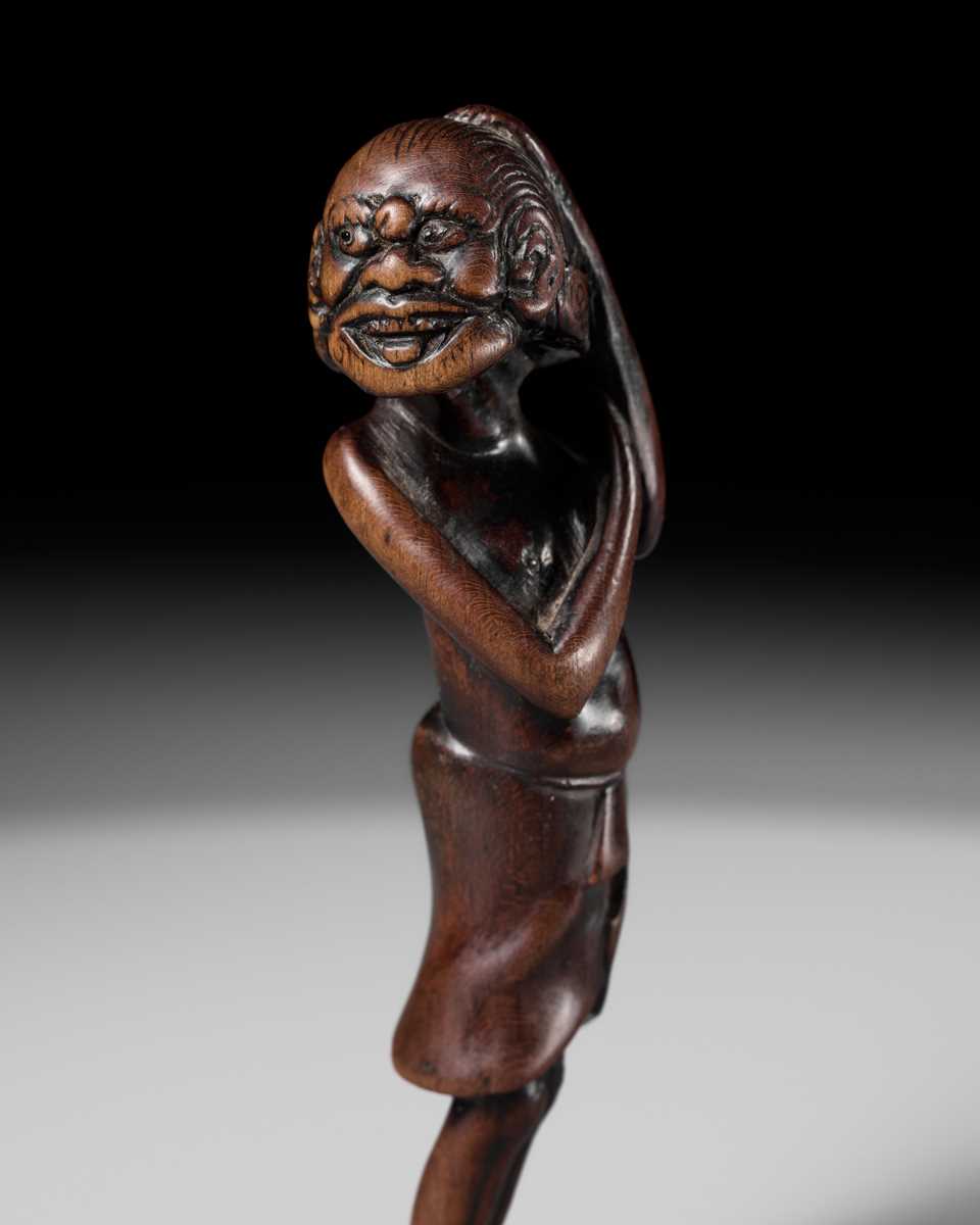A SUPERB TALL WOOD NETSUKE OF AN EMACIATED SOUTH SEA ISLANDER