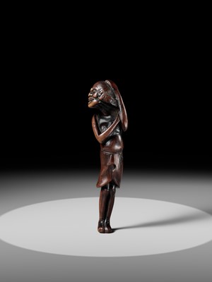 A SUPERB TALL WOOD NETSUKE OF AN EMACIATED SOUTH SEA ISLANDER
