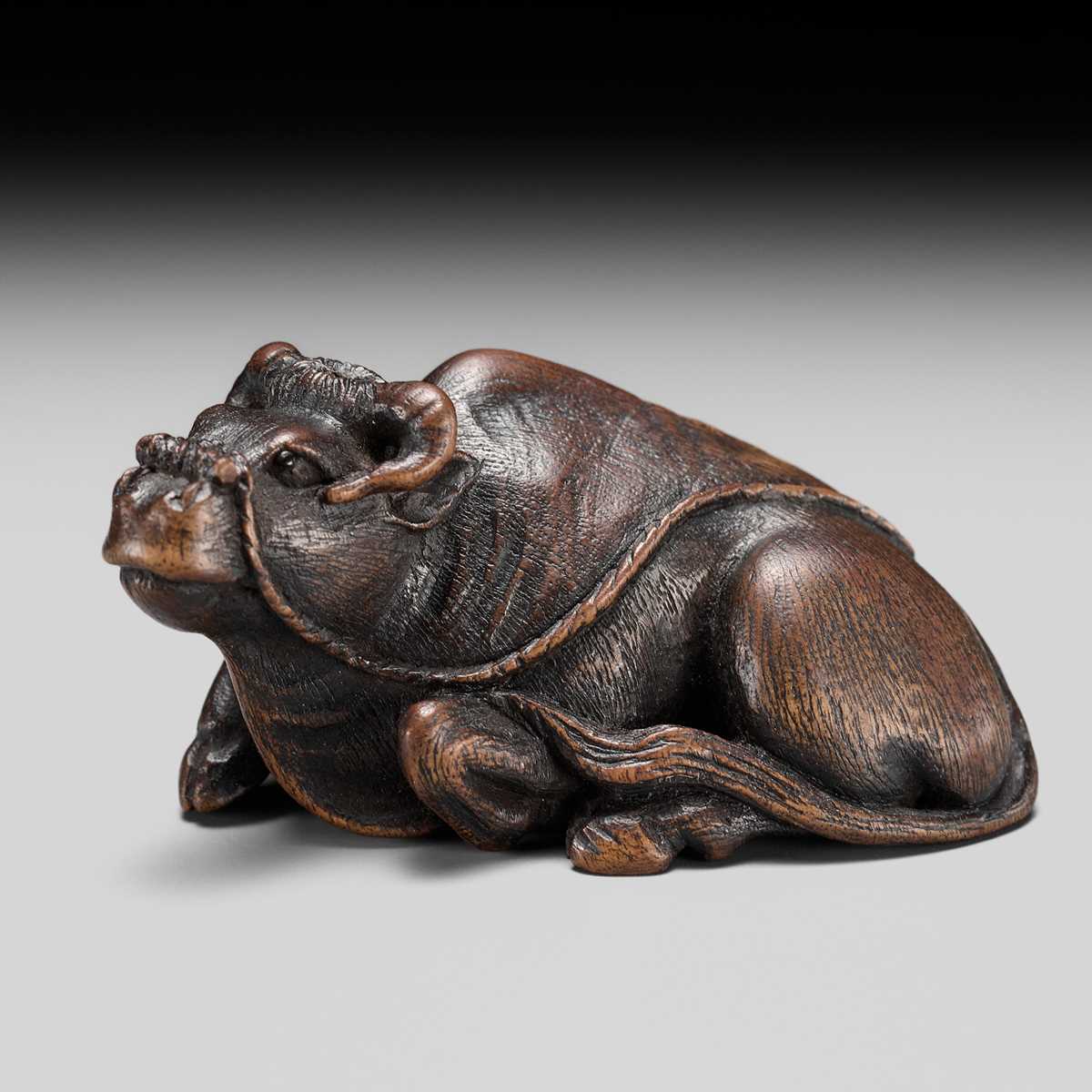 Lot 191 - ITTAN: A FINE WOOD NETSUKE OF A RECUMBENT OX