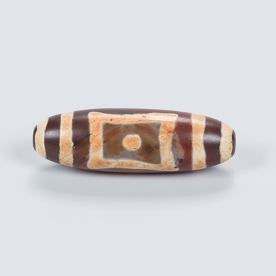 Lot 687 - A TIBETAN AGATE ‘DZI’ BEAD