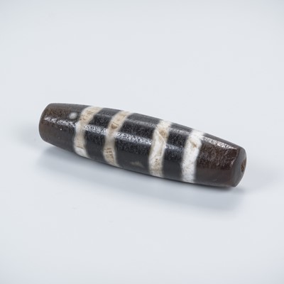 Lot 684 - A TIBETAN AGATE ‘CHUNG DZI’ BEAD, c. 500-1000 CE