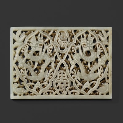 Lot 158 - A PALE CELADON JADE RETICULATED ‘DRAGONS’ PLAQUE, MING DYNASTY