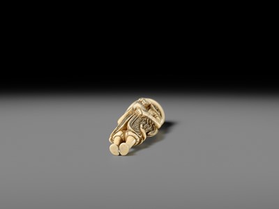 AN IVORY NETSUKE OF A DUTCHMAN WITH COCKEREL