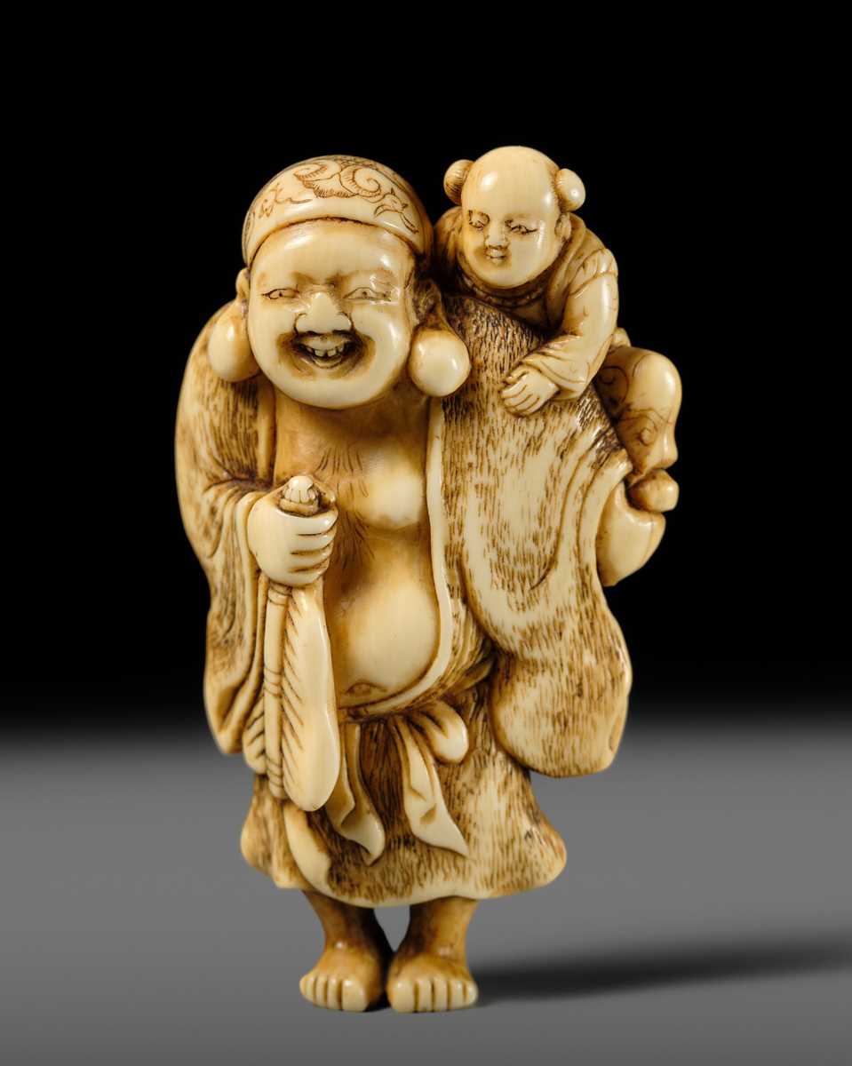 Lot 124 - OKATOMO: A FINE IVORY NETSUKE OF HOTEI WITH A KARAKO