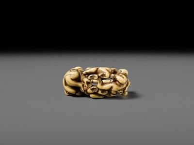 AN AMUSING IVORY NETSUKE OF A GROUP OF MONKEYS CARRYING A BAMBOO POLE