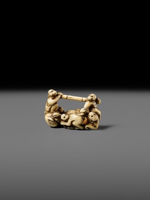 AN AMUSING IVORY NETSUKE OF A GROUP OF MONKEYS CARRYING A BAMBOO POLE