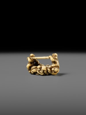 AN AMUSING IVORY NETSUKE OF A GROUP OF MONKEYS CARRYING A BAMBOO POLE