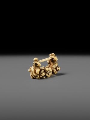 AN AMUSING IVORY NETSUKE OF A GROUP OF MONKEYS CARRYING A BAMBOO POLE