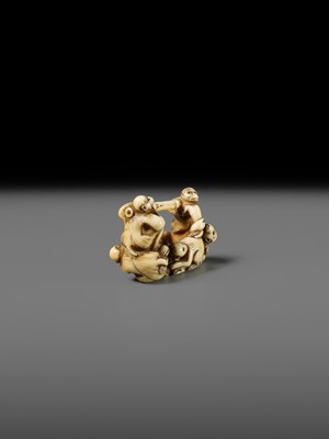 AN AMUSING IVORY NETSUKE OF A GROUP OF MONKEYS CARRYING A BAMBOO POLE