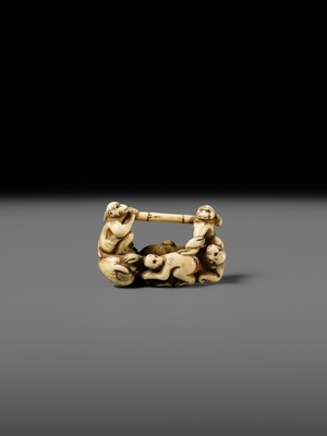 AN AMUSING IVORY NETSUKE OF A GROUP OF MONKEYS CARRYING A BAMBOO POLE