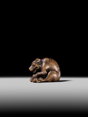 Lot 146 - A FINE WOOD NETSUKE OF A WOLF WITH HAUNCH OF VENISON, ATTRIBUTED TO OKATOMO