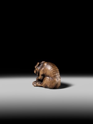 Lot 146 - A FINE WOOD NETSUKE OF A WOLF WITH HAUNCH OF VENISON, ATTRIBUTED TO OKATOMO