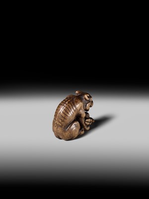 Lot 146 - A FINE WOOD NETSUKE OF A WOLF WITH HAUNCH OF VENISON, ATTRIBUTED TO OKATOMO
