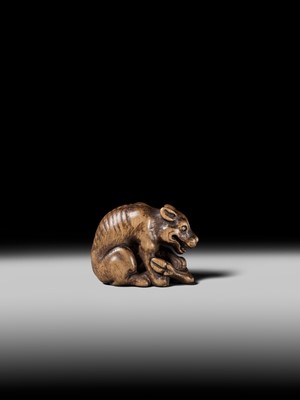 Lot 146 - A FINE WOOD NETSUKE OF A WOLF WITH HAUNCH OF VENISON, ATTRIBUTED TO OKATOMO