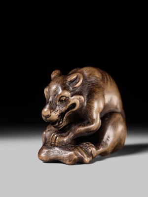 Lot 146 - A FINE WOOD NETSUKE OF A WOLF WITH HAUNCH OF VENISON, ATTRIBUTED TO OKATOMO