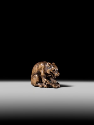Lot 146 - A FINE WOOD NETSUKE OF A WOLF WITH HAUNCH OF VENISON, ATTRIBUTED TO OKATOMO
