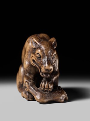 Lot 146 - A FINE WOOD NETSUKE OF A WOLF WITH HAUNCH OF VENISON, ATTRIBUTED TO OKATOMO