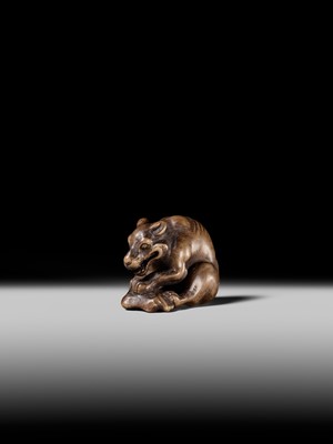 Lot 146 - A FINE WOOD NETSUKE OF A WOLF WITH HAUNCH OF VENISON, ATTRIBUTED TO OKATOMO