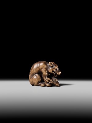 Lot 146 - A FINE WOOD NETSUKE OF A WOLF WITH HAUNCH OF VENISON, ATTRIBUTED TO OKATOMO
